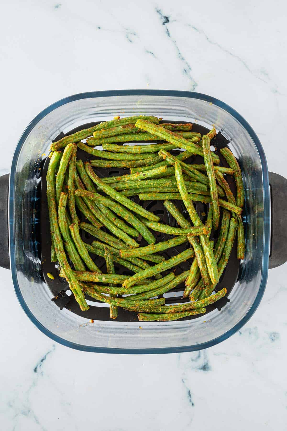 Fertig gegarte gr&uuml;ne Bohnen in einem Glas Airfryer-Korb.