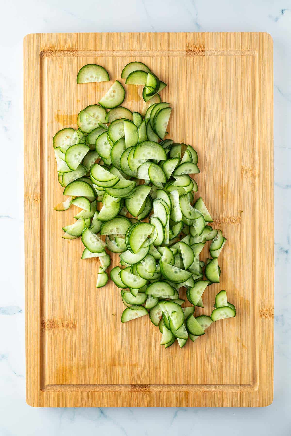Eine in feine Halbmonde geschnittene Salatgurke.