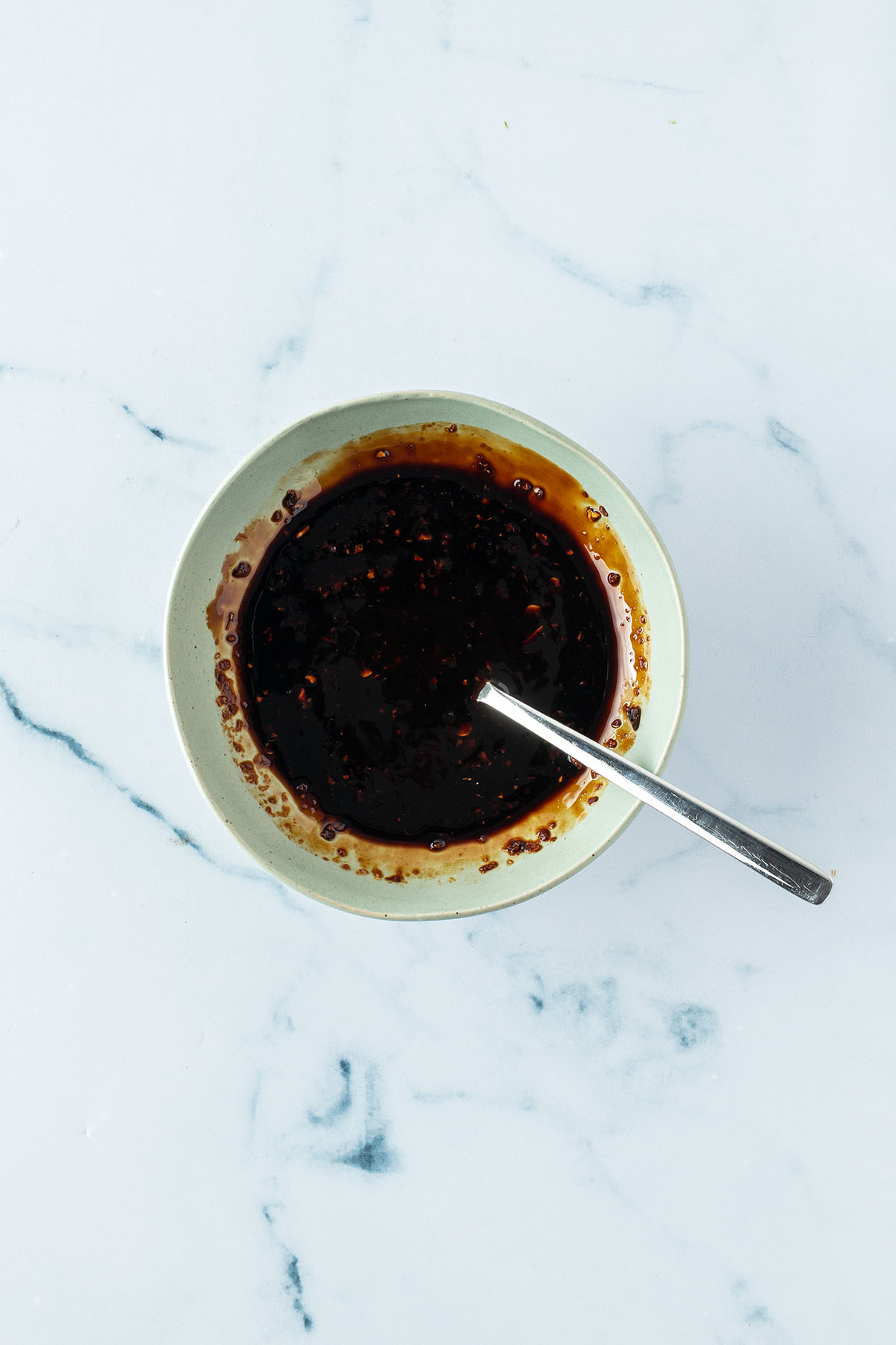 Vogelperspektive auf eine kleine Sch&uuml;ssel mit einer dickfl&uuml;ssigen Hoisin-Sauce.
