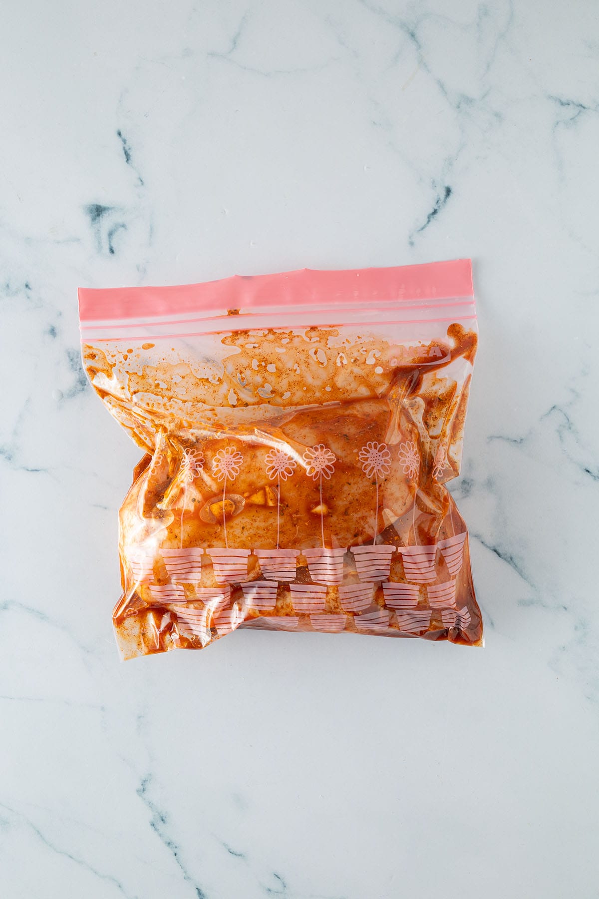 Rohes H&auml;hnchen in einer Marinade in einem verschlossenen Plastikbeutel.