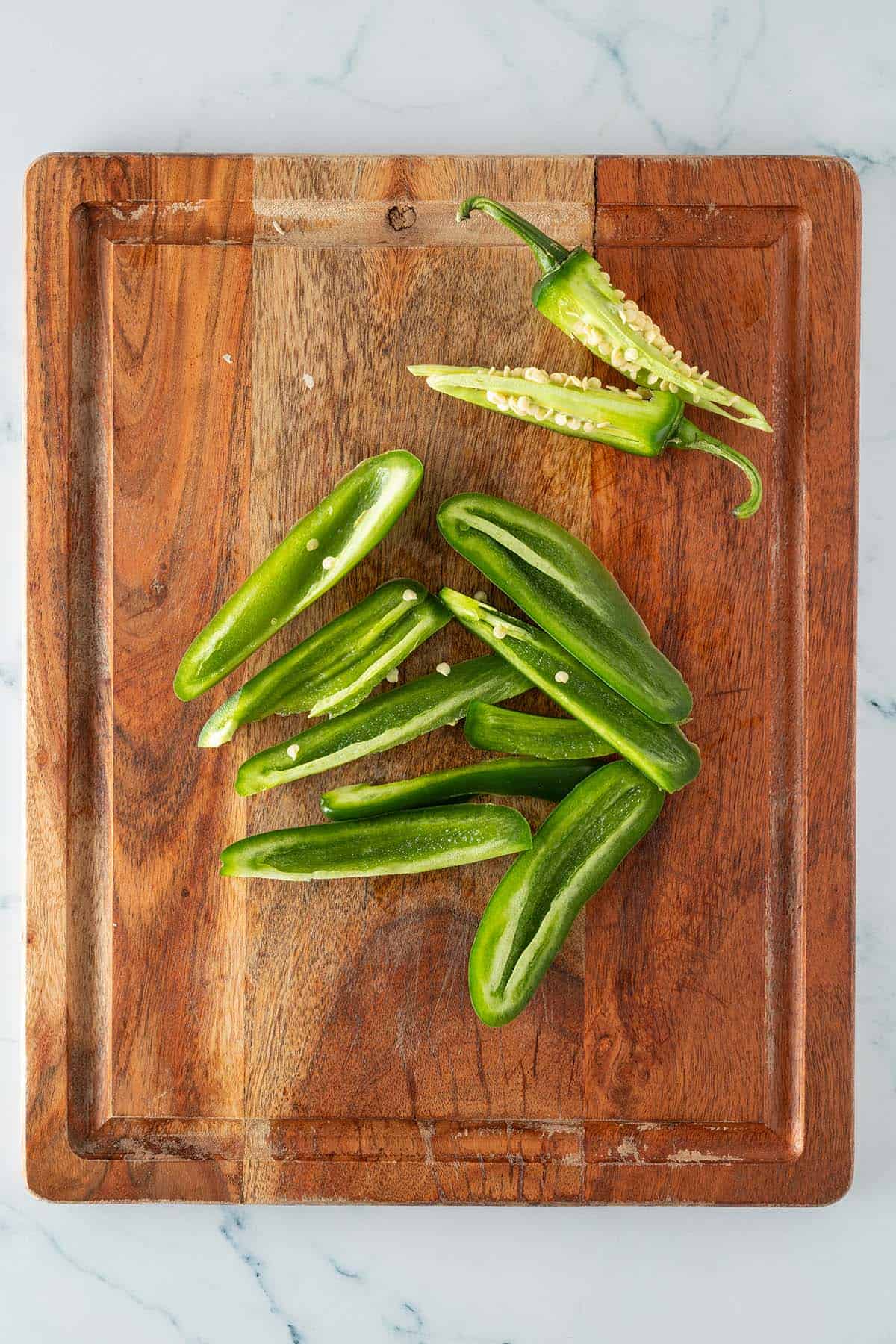Jalape&ntilde;o Chilis auf einem Brett, Kerne und Fasern von dem gr&uuml;nen Teil entfernt.