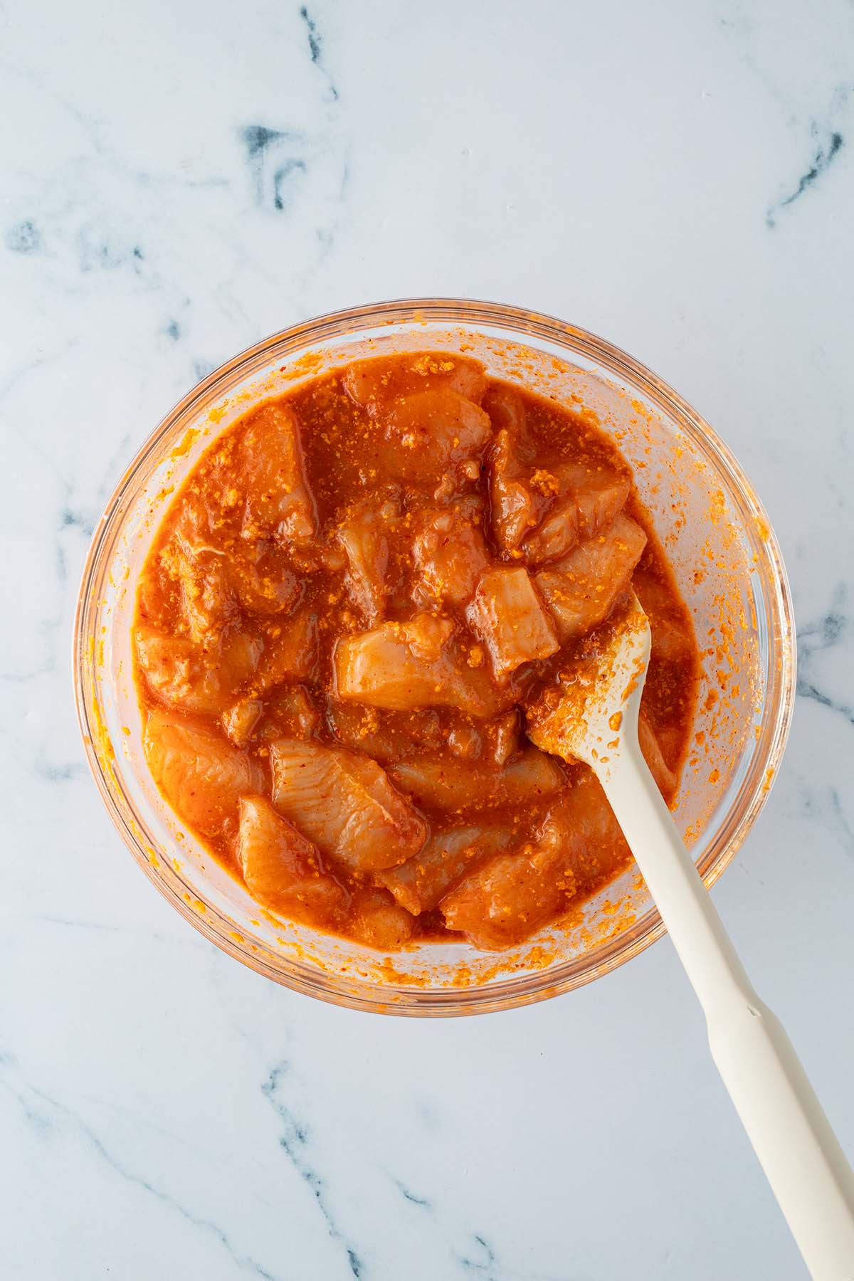 H&auml;hnchenst&uuml;cke werden mit der Chicken Satay Marinade in einer gro&szlig;en Sch&uuml;ssel verr&uuml;hrt.