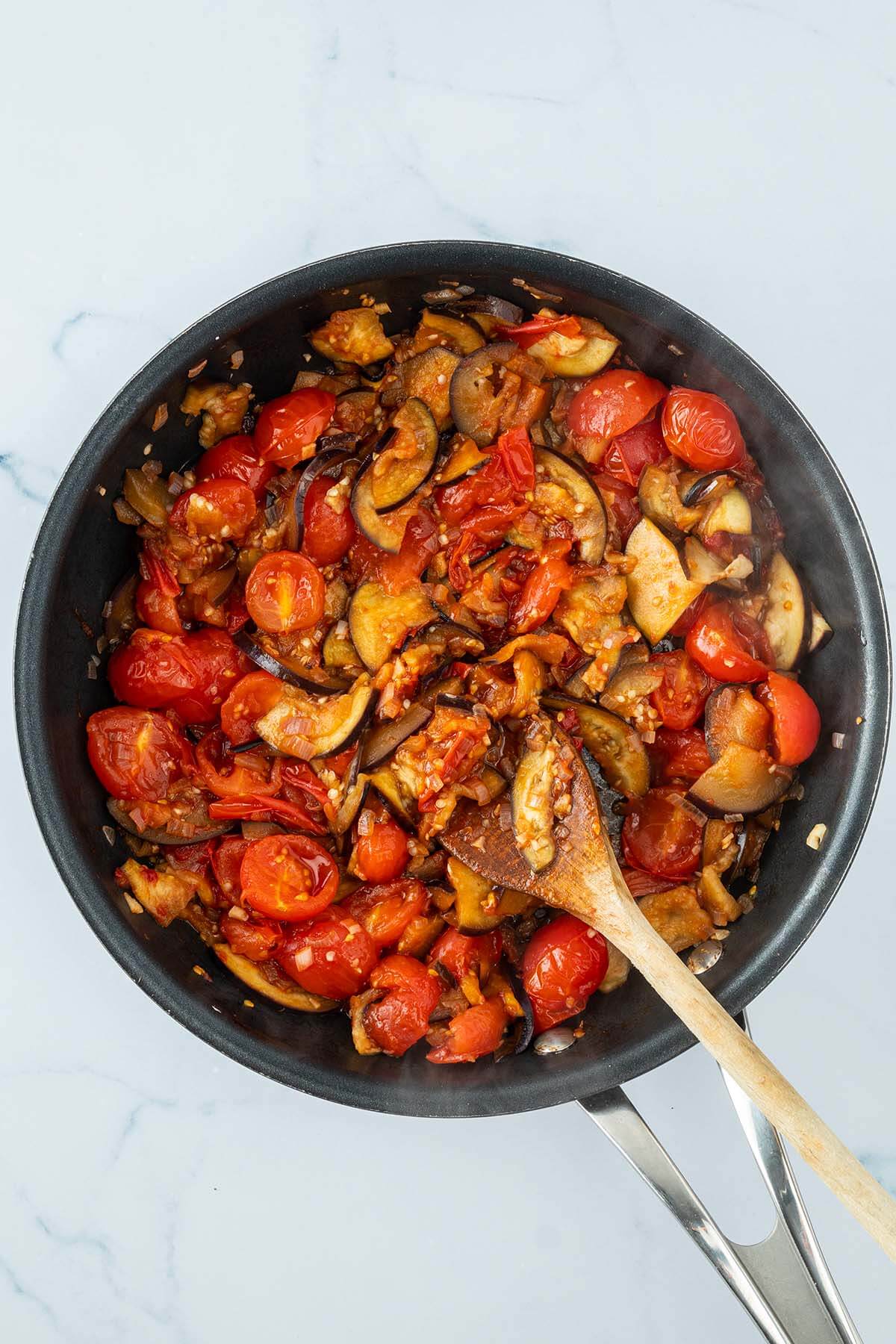 Weich gebratenes Tomaten-Auberginen-Gem&uuml;se in einer Pfanne.