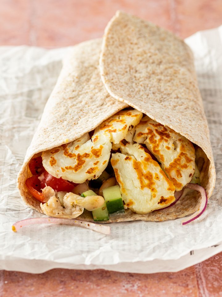 Halloumi Wrap auf einem St&uuml;ck Zeitungspapier.