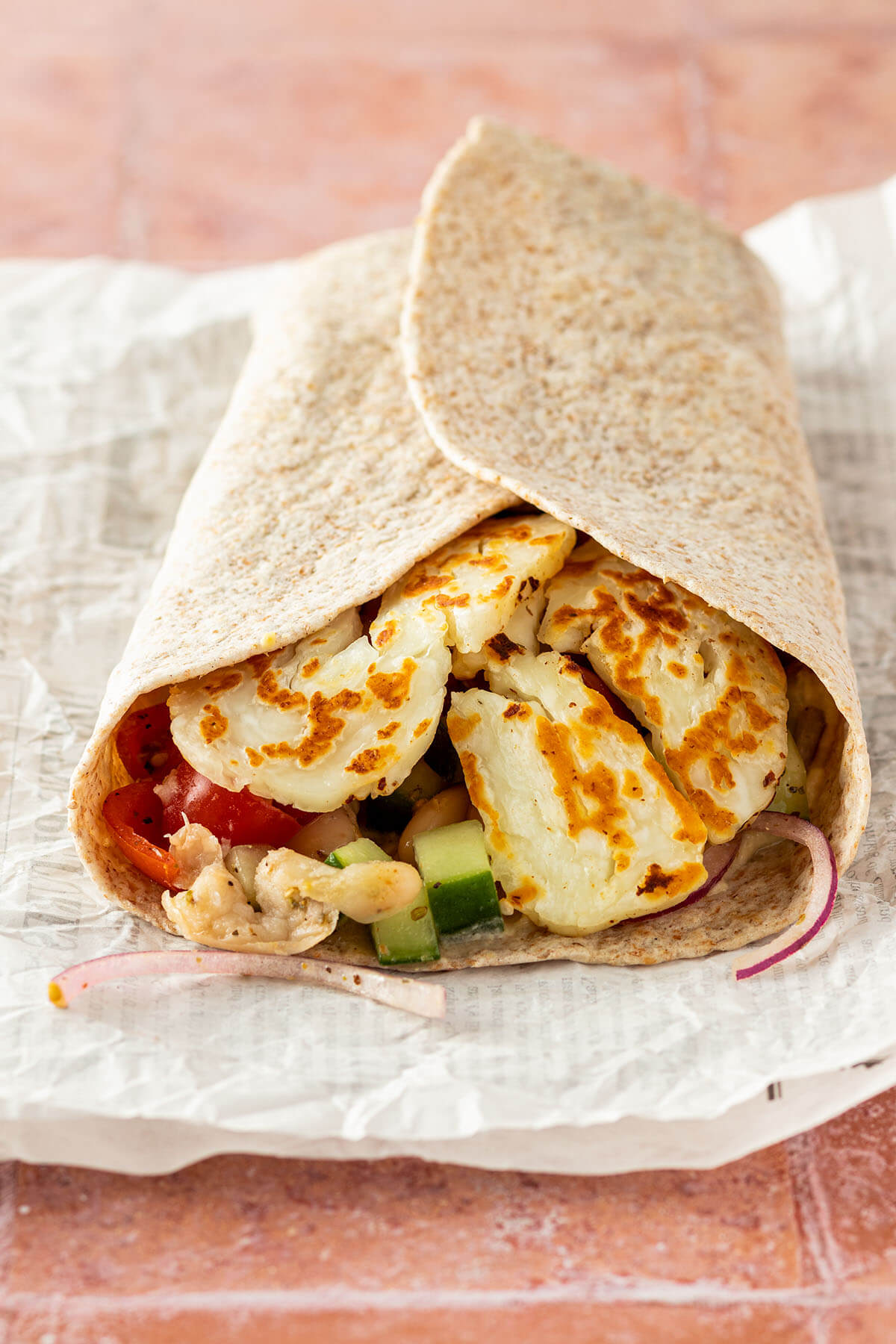 Halloumi Wrap auf einem St&uuml;ck Zeitungspapier.