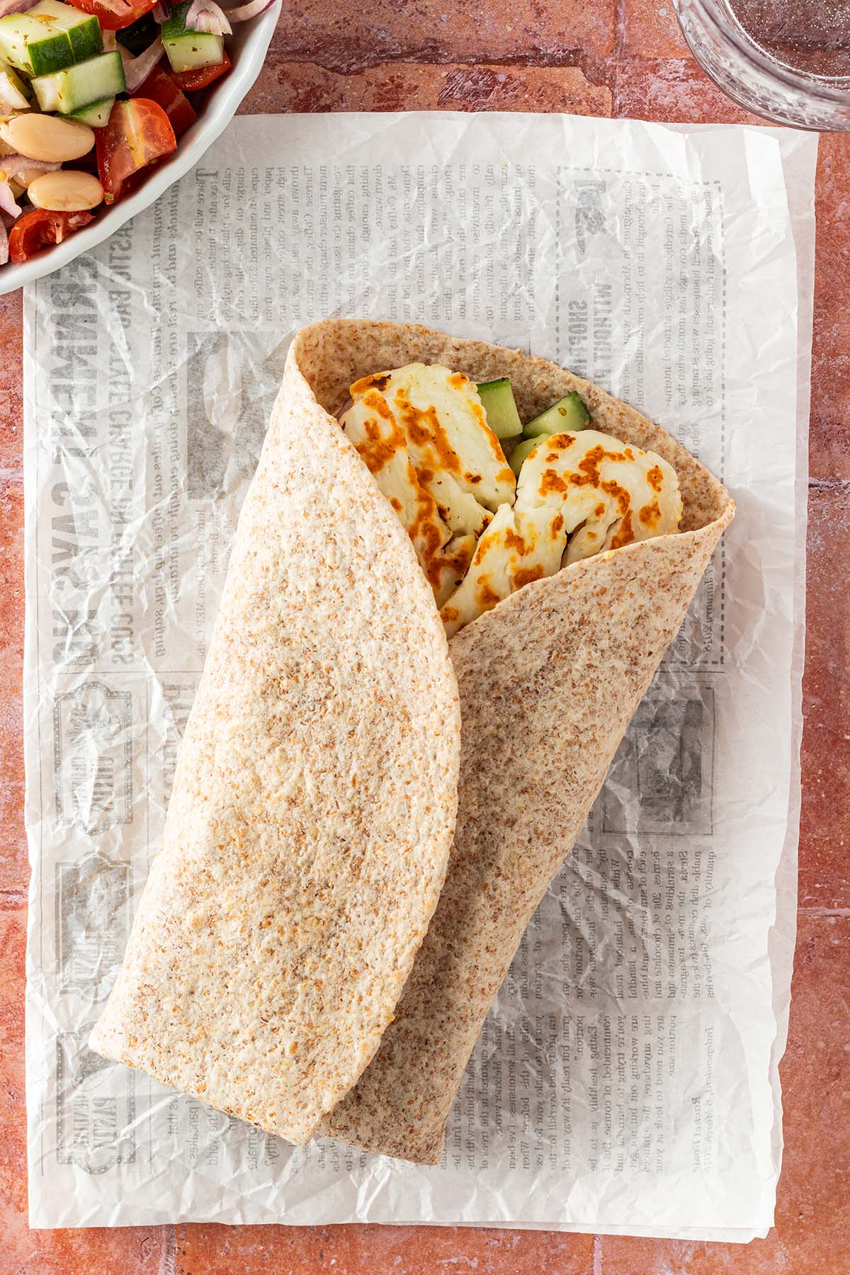 Vogelperspektive auf den Halloumi-Wrap, Deko im Bildrand.