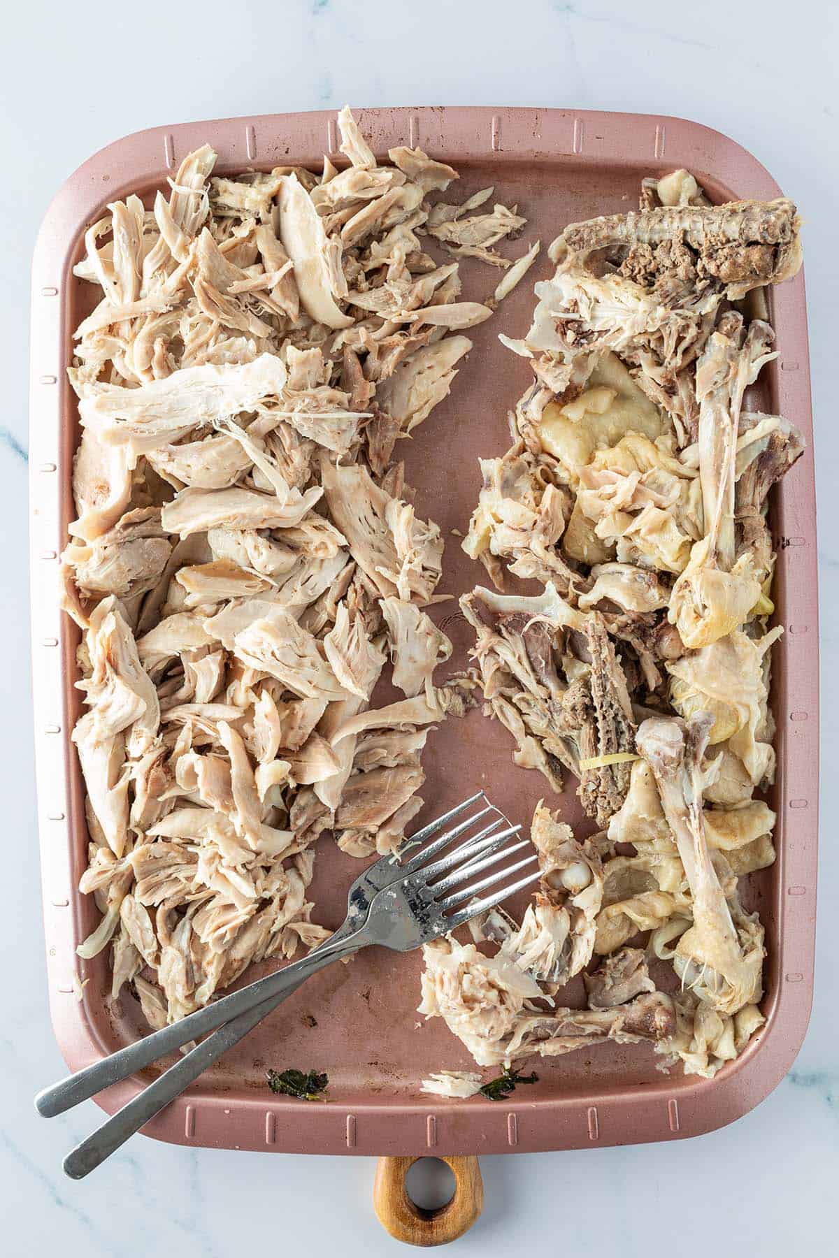 Gekochte H&auml;hnchenschenkel bei denen das Fleisch vom den Knochen und der Haut getrennt und in mundgerechte St&uuml;cke zerkleinert wurden.