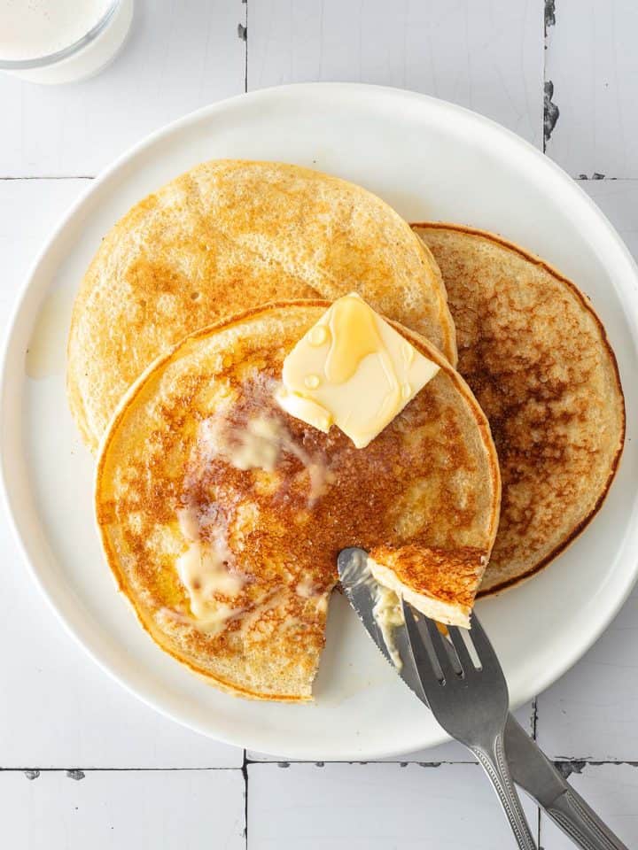 Drei H&uuml;ttenk&auml;se Pancakes auf einem Teller, auf wei&szlig;en Flie&szlig;en.