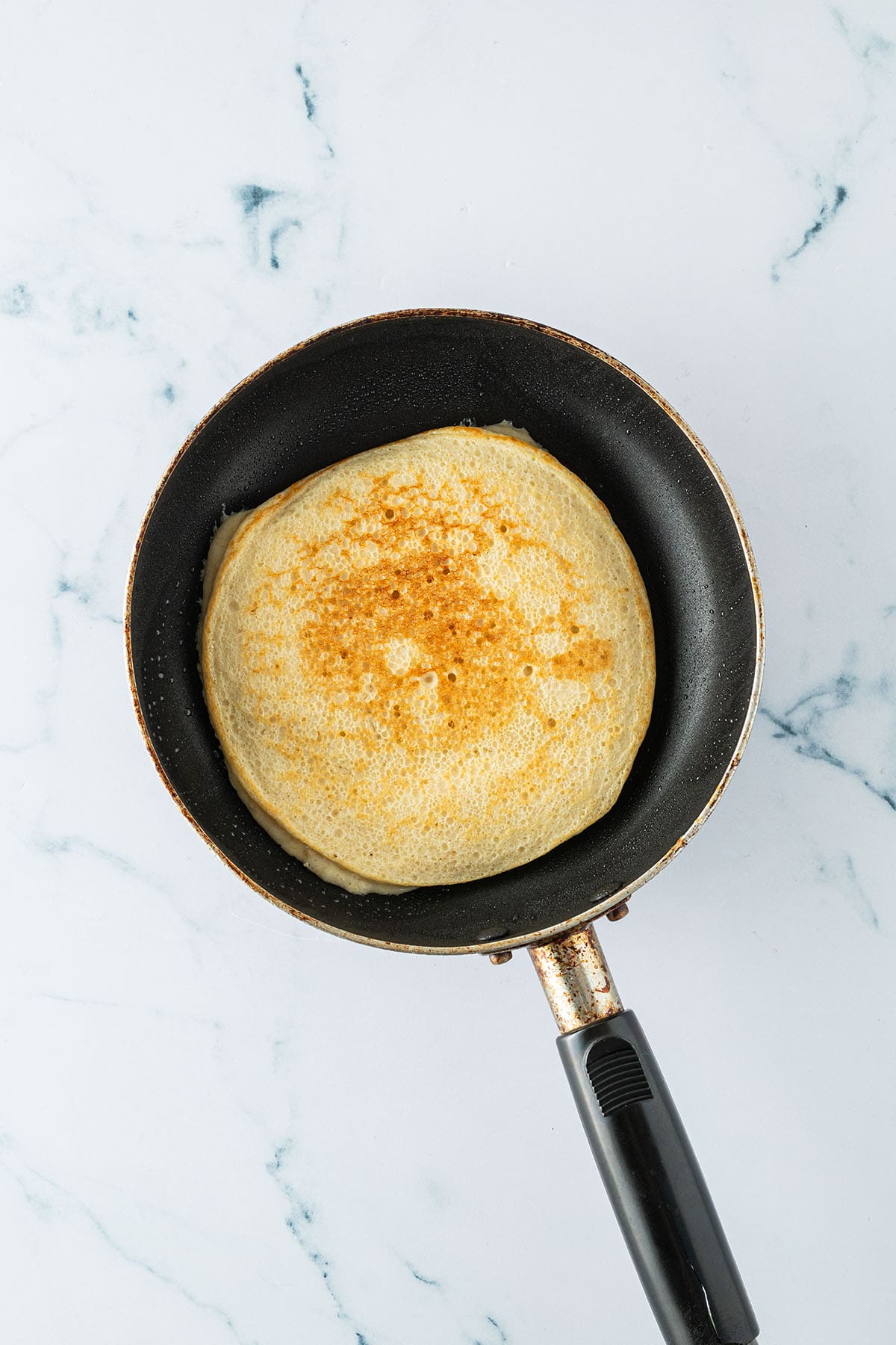 H&uuml;ttenk&auml;se Pancake in einer Pfanne nach dem Wenden.