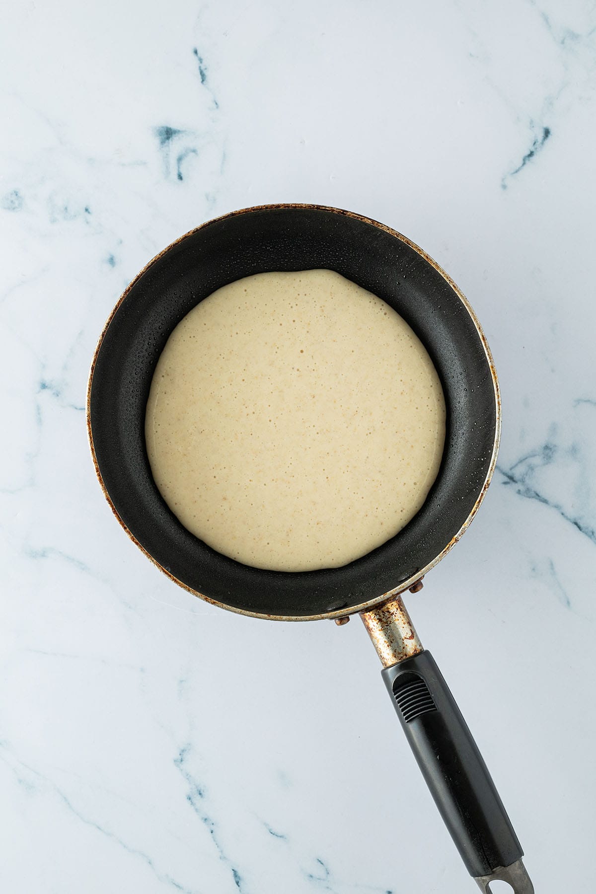 Eine kleine Pfanne mit rohem Pancake Teig.