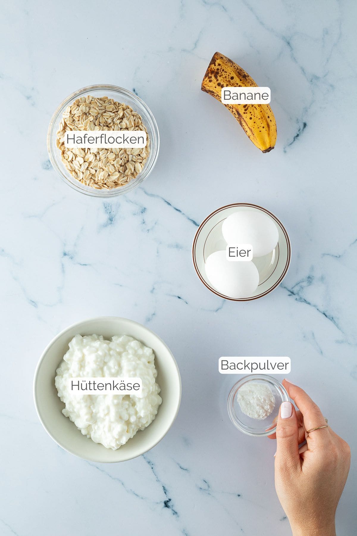 Alle Zutaten mit jeweiligen Textbeschriftungen, die f&uuml;r die Pancakes mit H&uuml;ttenk&auml;se ben&ouml;tigt werden.