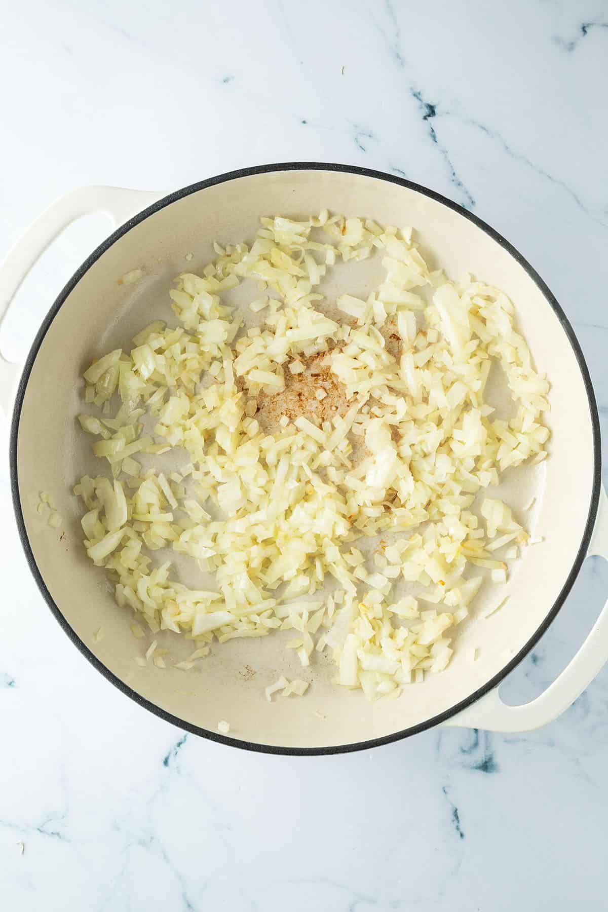 Glasig angebratene Zwiebeln in einer gro&szlig;en Pfanne.