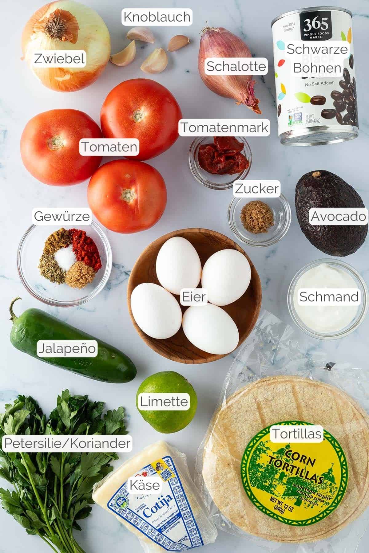 Alle Zutaten mit Textbeschriftungen, die f&uuml;r hausgemachte Huevos Rancheros ben&ouml;tigt werden.