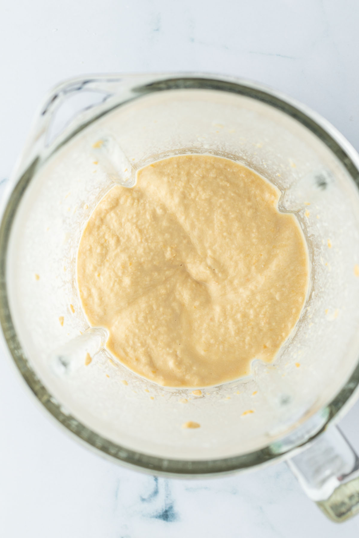 Vogelperspektive auf einen Standmixer mit einem cremigen Hummus.