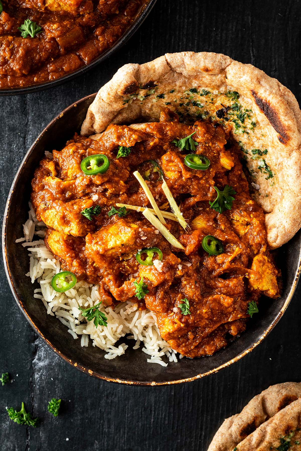 Indisches H&auml;hnchen Curry in einer Sch&uuml;ssel serviert mit Reis und Naan Brot.