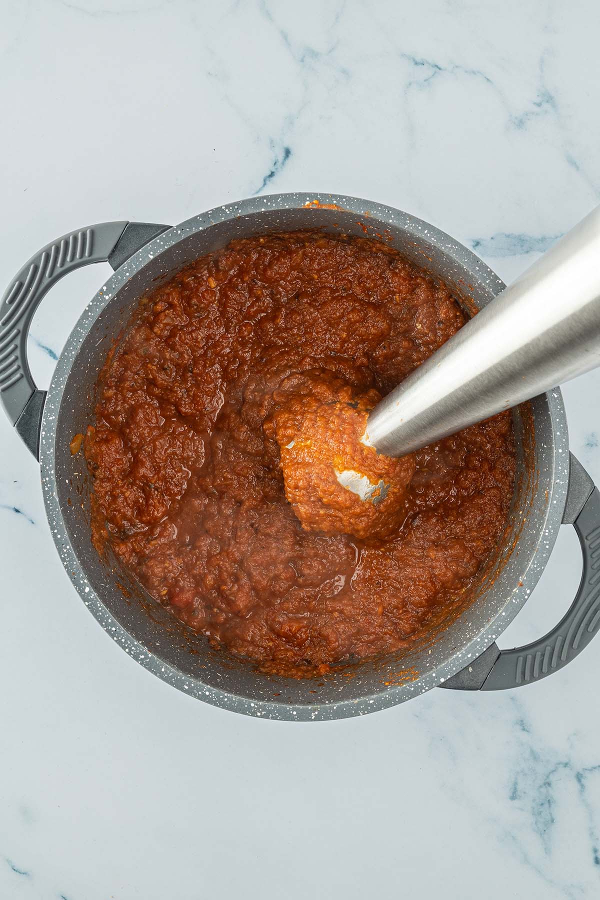 P&uuml;rierstab in einem Topf mit einer cremig, s&auml;migen Tikka Masala Tomatensauce.