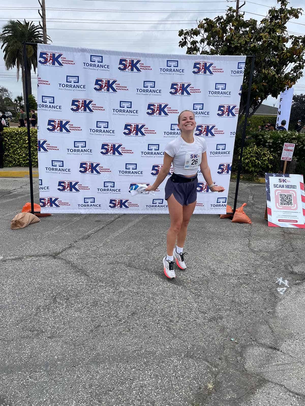 Person steht vor einem 5K Banner nach einem 5 Kilometer Rennen.