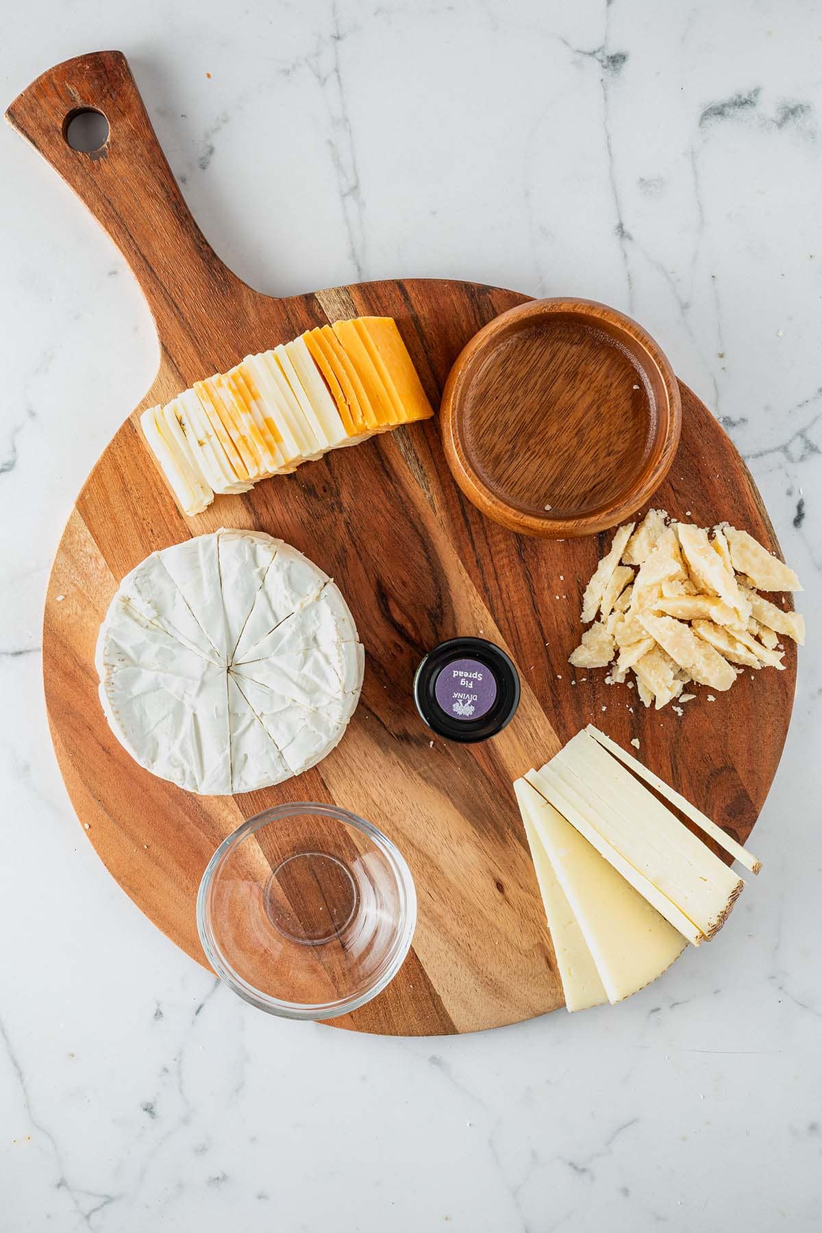 Angeschnittene K&auml;se platziert auf der K&auml;seplatte mit zwei leeren Sch&uuml;sseln.