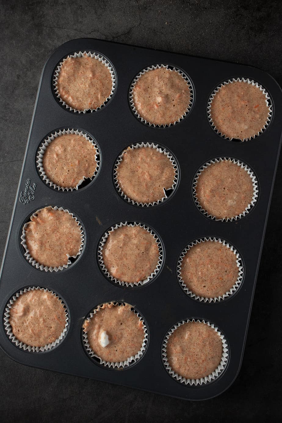 Muffinteig auf 12 Muffinf&ouml;rmchen verteilt.