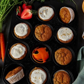 Kalorienarme Karottenmuffins in einem Muffig-Blech, ein Teil davon mit Frischk&auml;se Frosting.