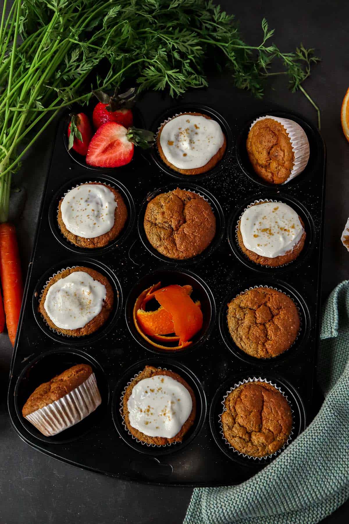 Kalorienarme Karottenmuffins in einem Muffig-Blech, ein Teil davon mit Frischk&auml;se Frosting.