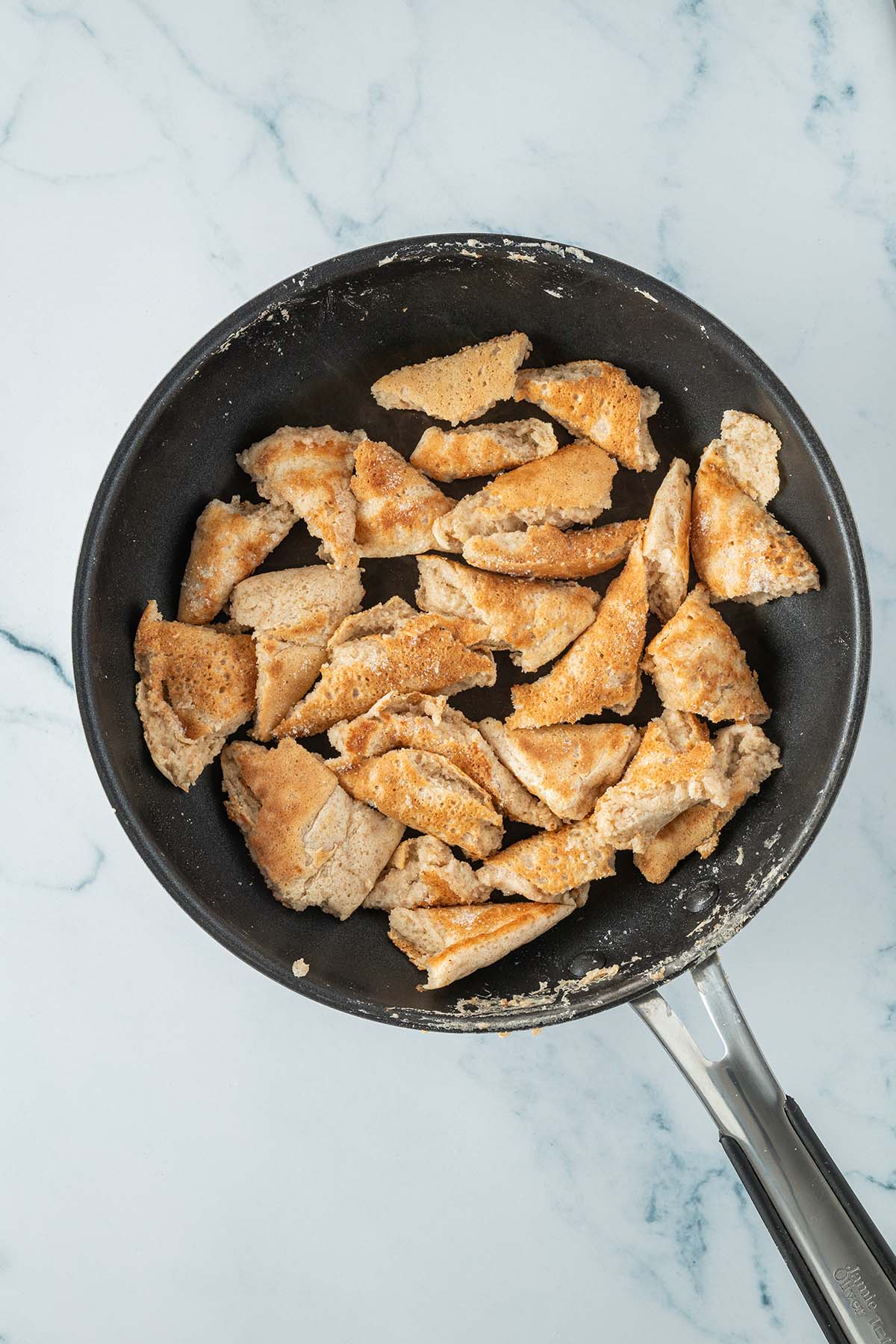 Zerst&uuml;ckelter Kaiserschmarrn in einer Pfanne.