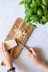 Zubereitungsbild zeigt wie Parmesan in kleine W&uuml;rfel geschnitten wird.