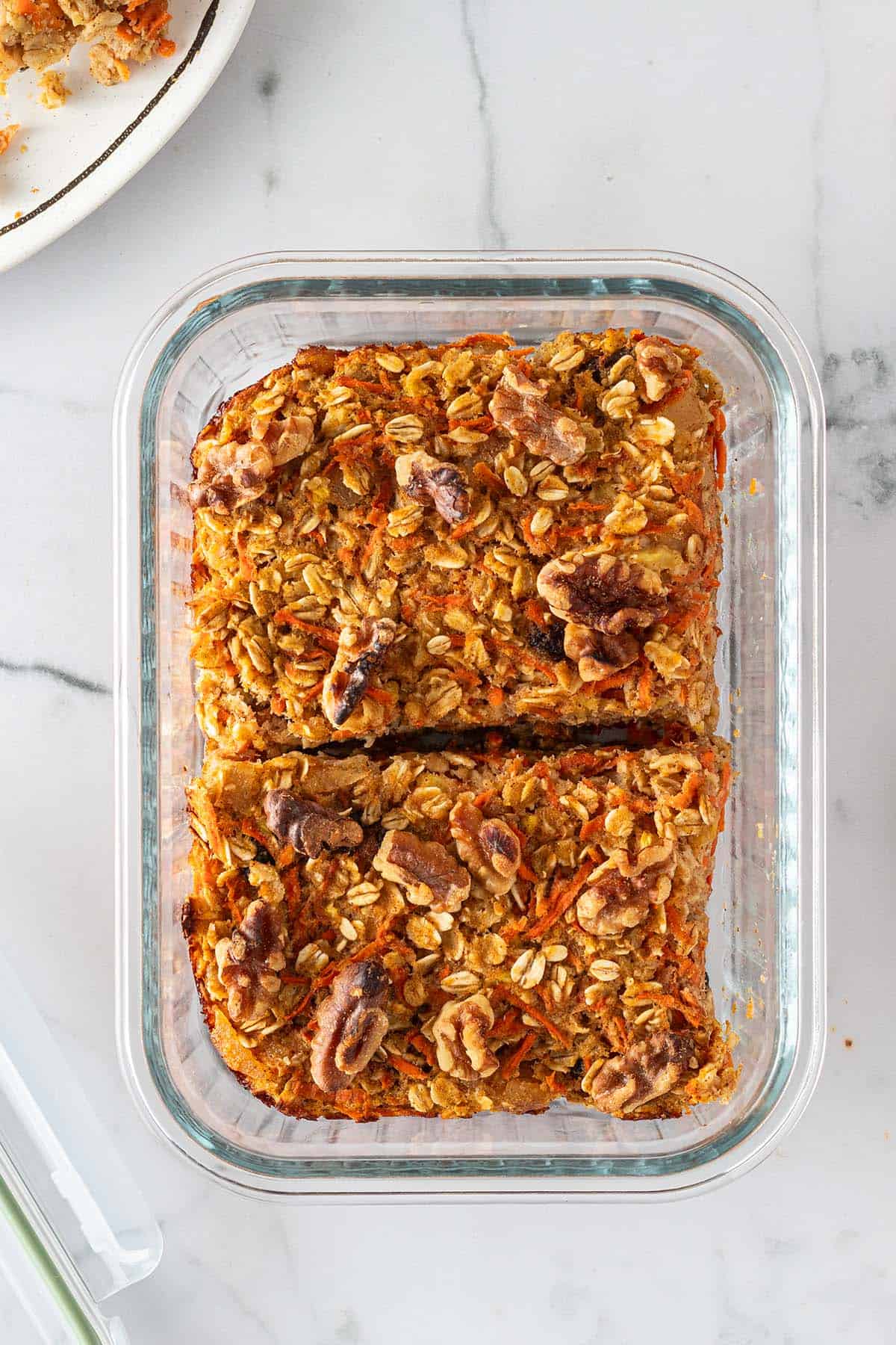 Zwei St&uuml;cke Karotten Baked Oatmeal in einer Glas-Frischaltebox.