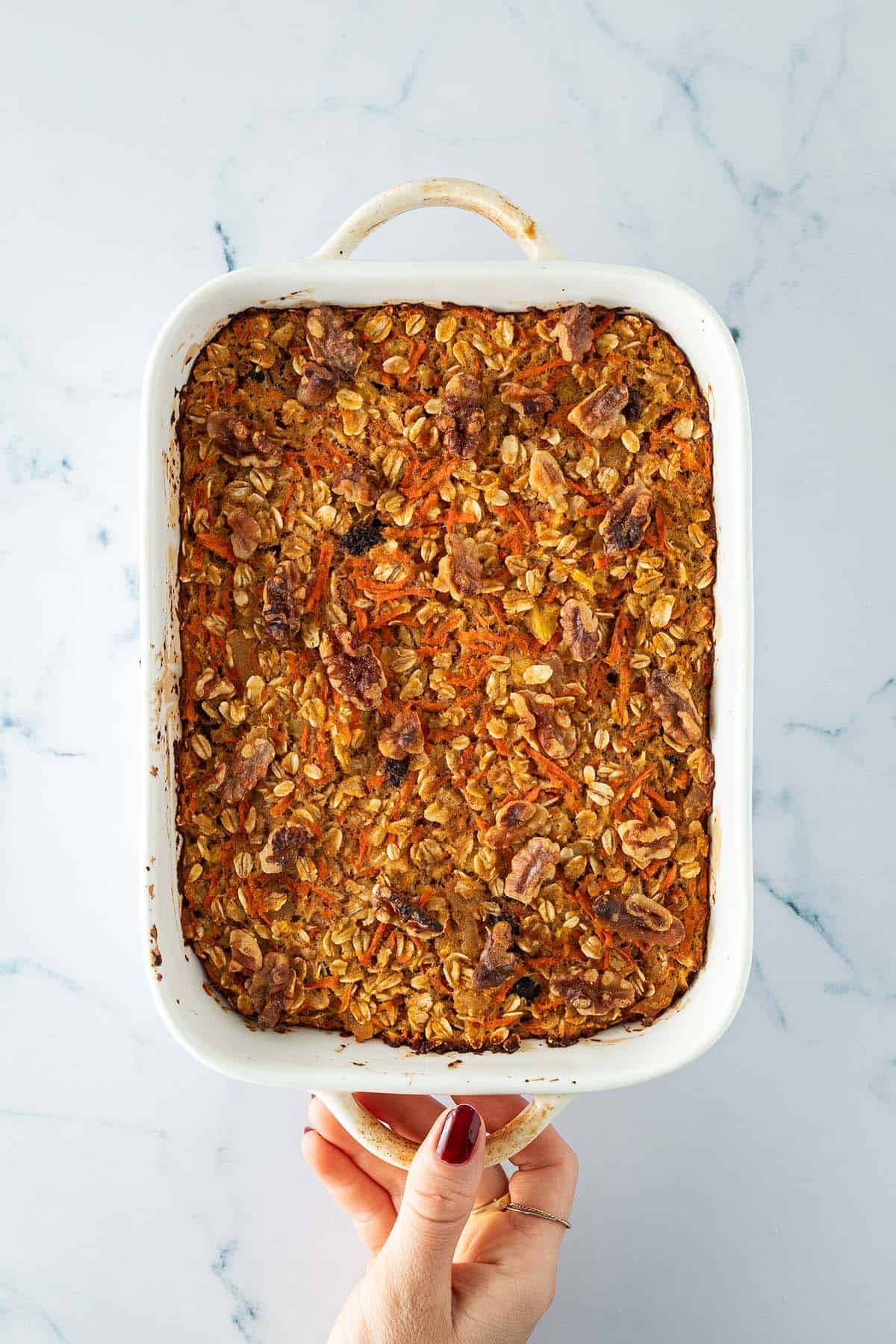Frisch gebackene Karotten-Baked-Oats in wei&szlig;er Auflaufform, von oben fotografiert.
