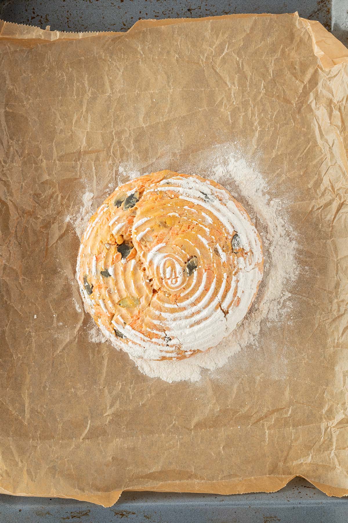 Brotleib wurde nach dem Gehen im Gehkörbchen auf eine mit Backpapier ausgelegtes Blech gestürzt.