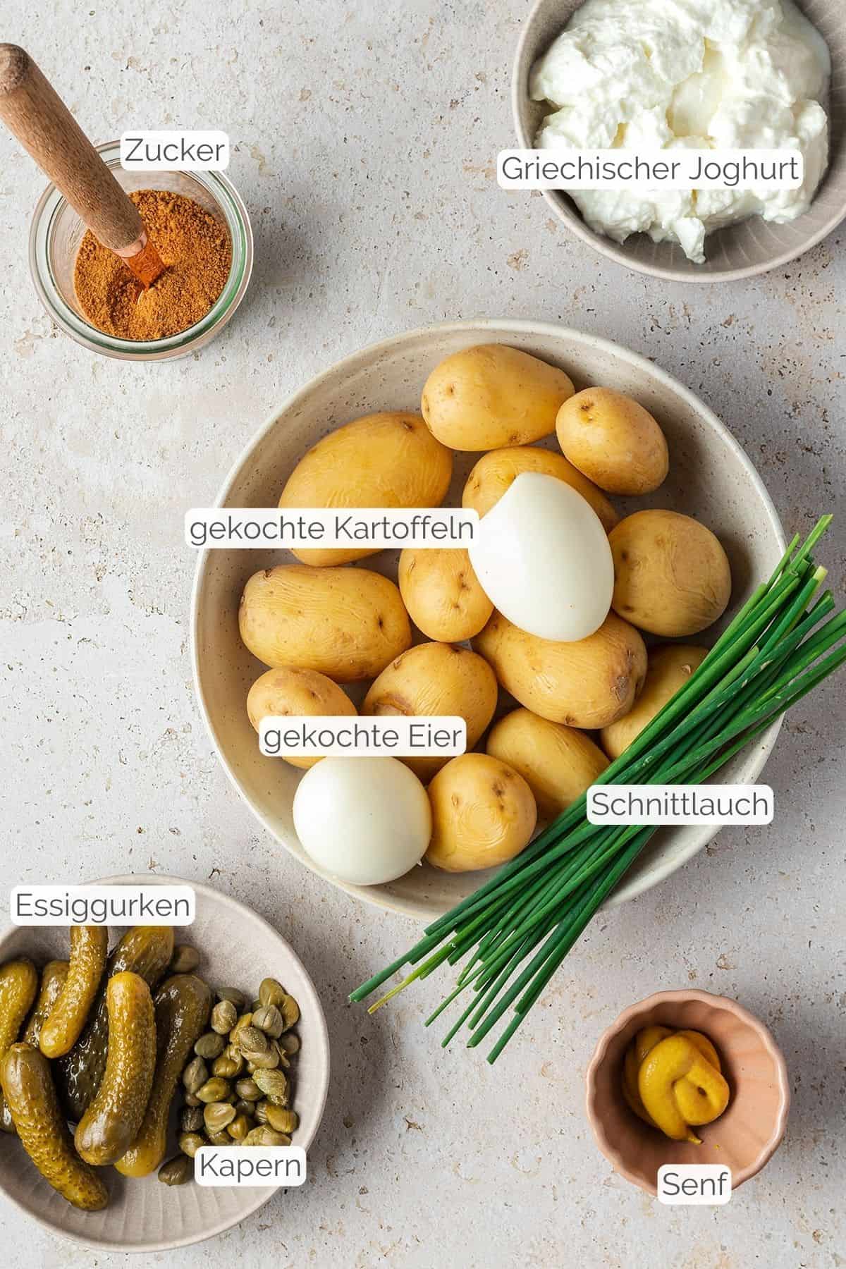 Alle Zutaten mit Textbeschriftungen, die f&uuml;r den Kartoffelsalat mit Joghurt ben&ouml;tigt werden.