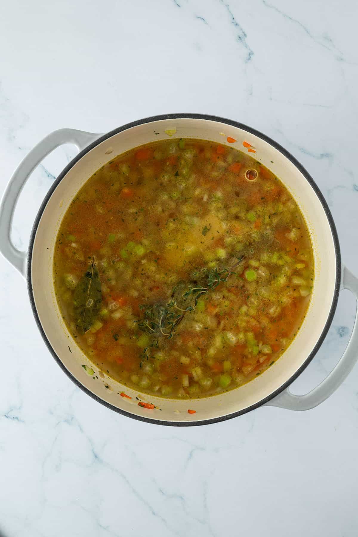 Gro&szlig;er Topf mit klarer Gem&uuml;sebr&uuml;he, feinem Suppengem&uuml;se und Kr&auml;utern und Kichererbsen.