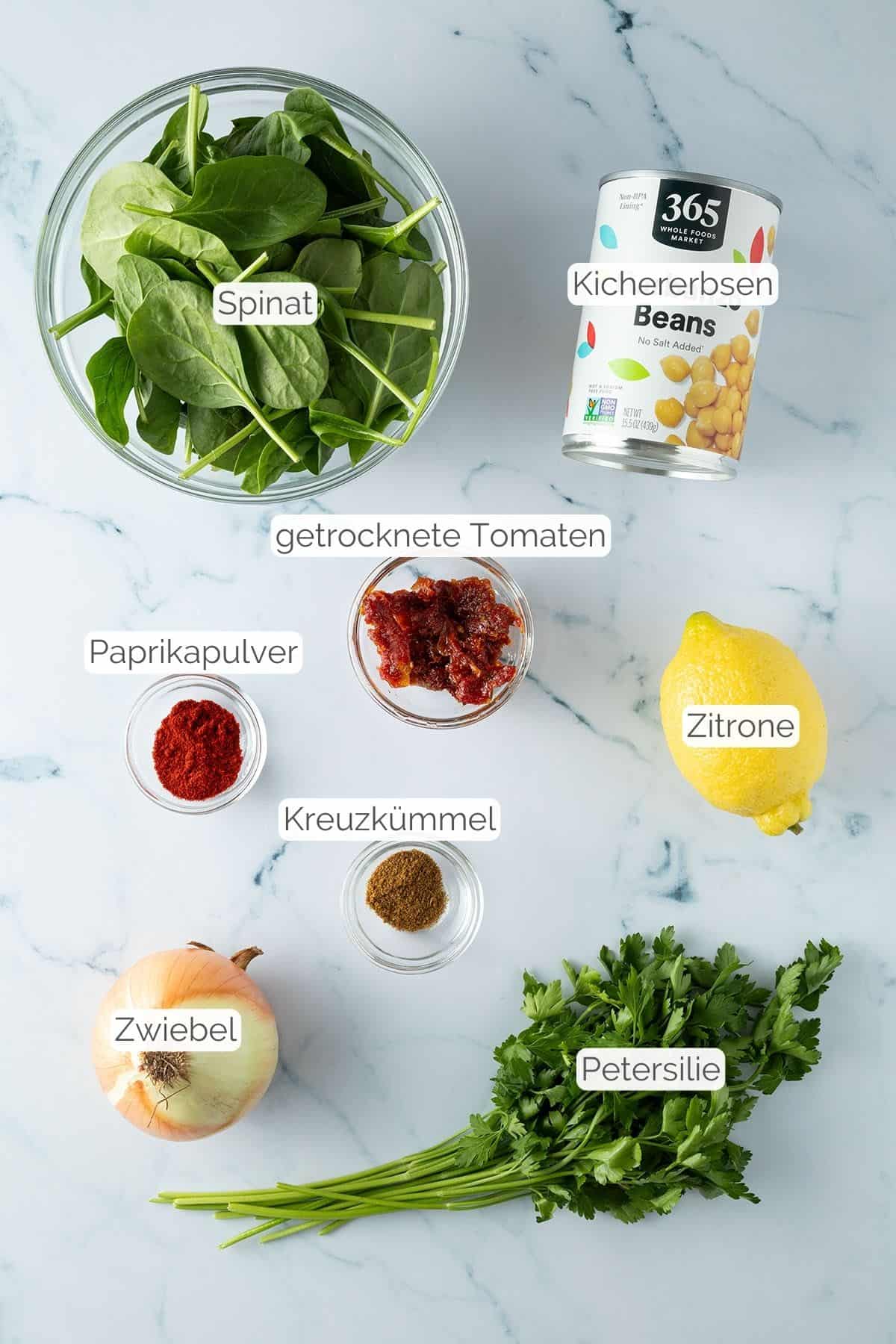 Alle Zutaten mit Textbeschriftungen, die f&uuml;r den Kichererbsensalat ben&ouml;tigt werden.