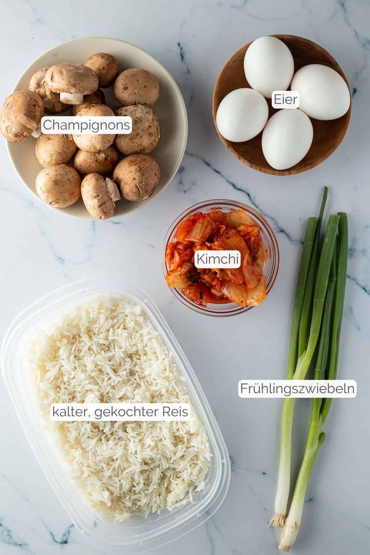 Alle Zutaten mit Textbeschriftungen, die f&uuml;r den Kimchi Reis ben&ouml;tigt werden.