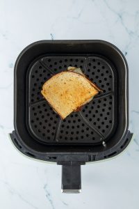 Sandwich im Korb einer Hei&szlig;luftfritteuse.