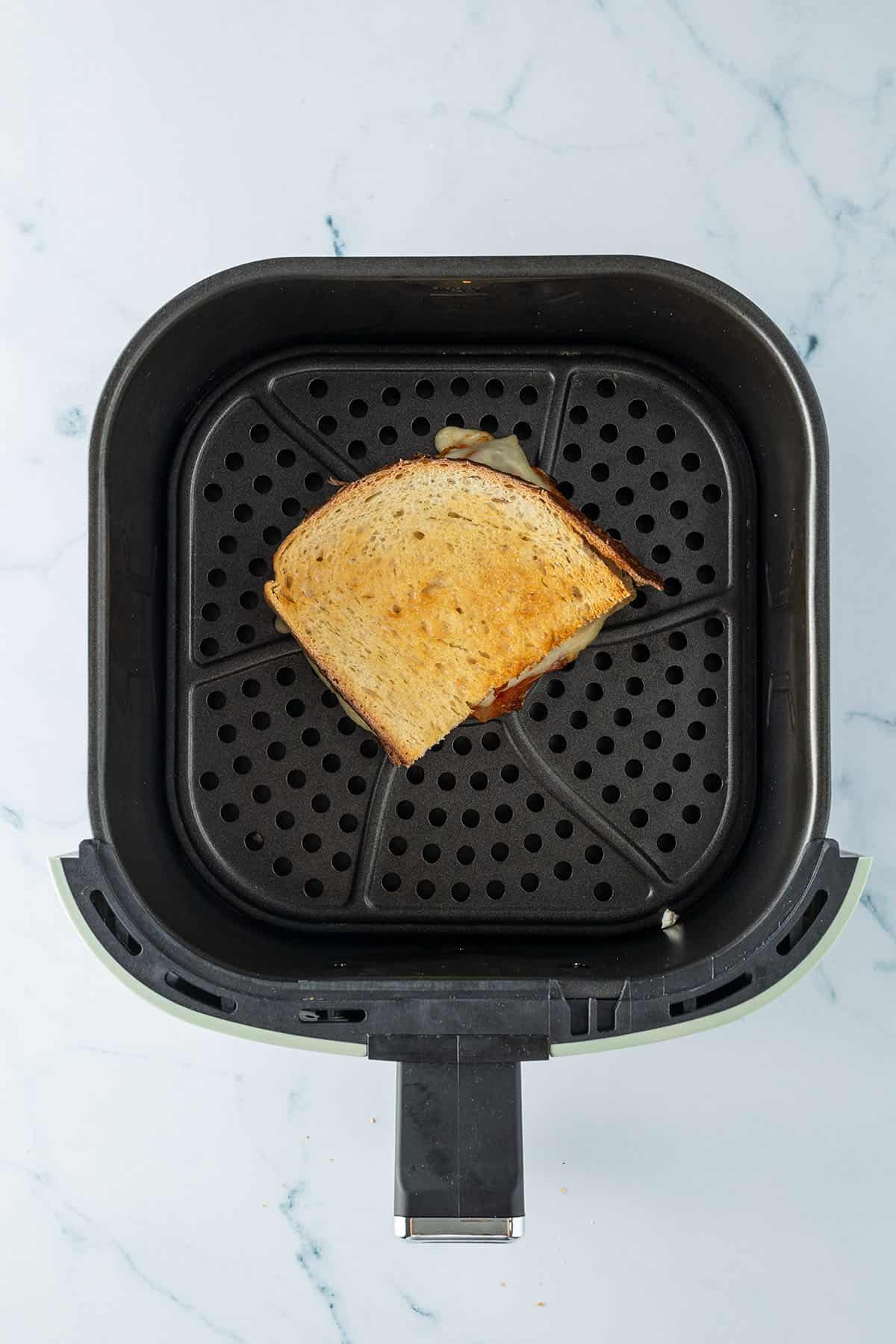 Sandwich im Korb einer Hei&szlig;luftfritteuse.