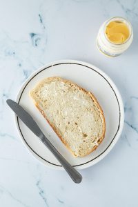 D&uuml;nn mit Mayonnaise bestrichenes Brot.