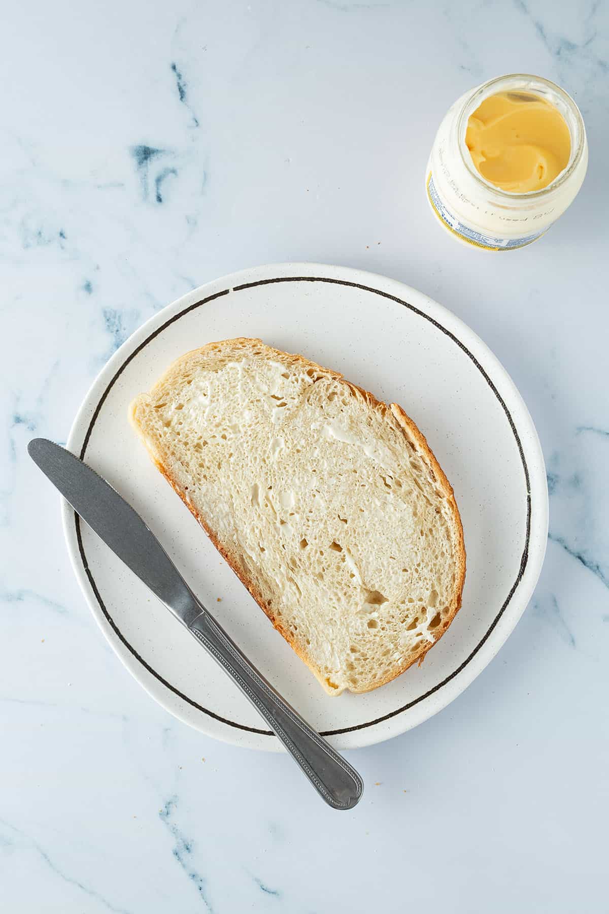 D&uuml;nn mit Mayonnaise bestrichenes Brot.