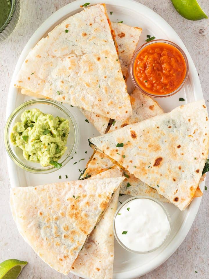 Kimchi Quesadilla auf einem Teller mit drei Dips, Deko im Bildrand.