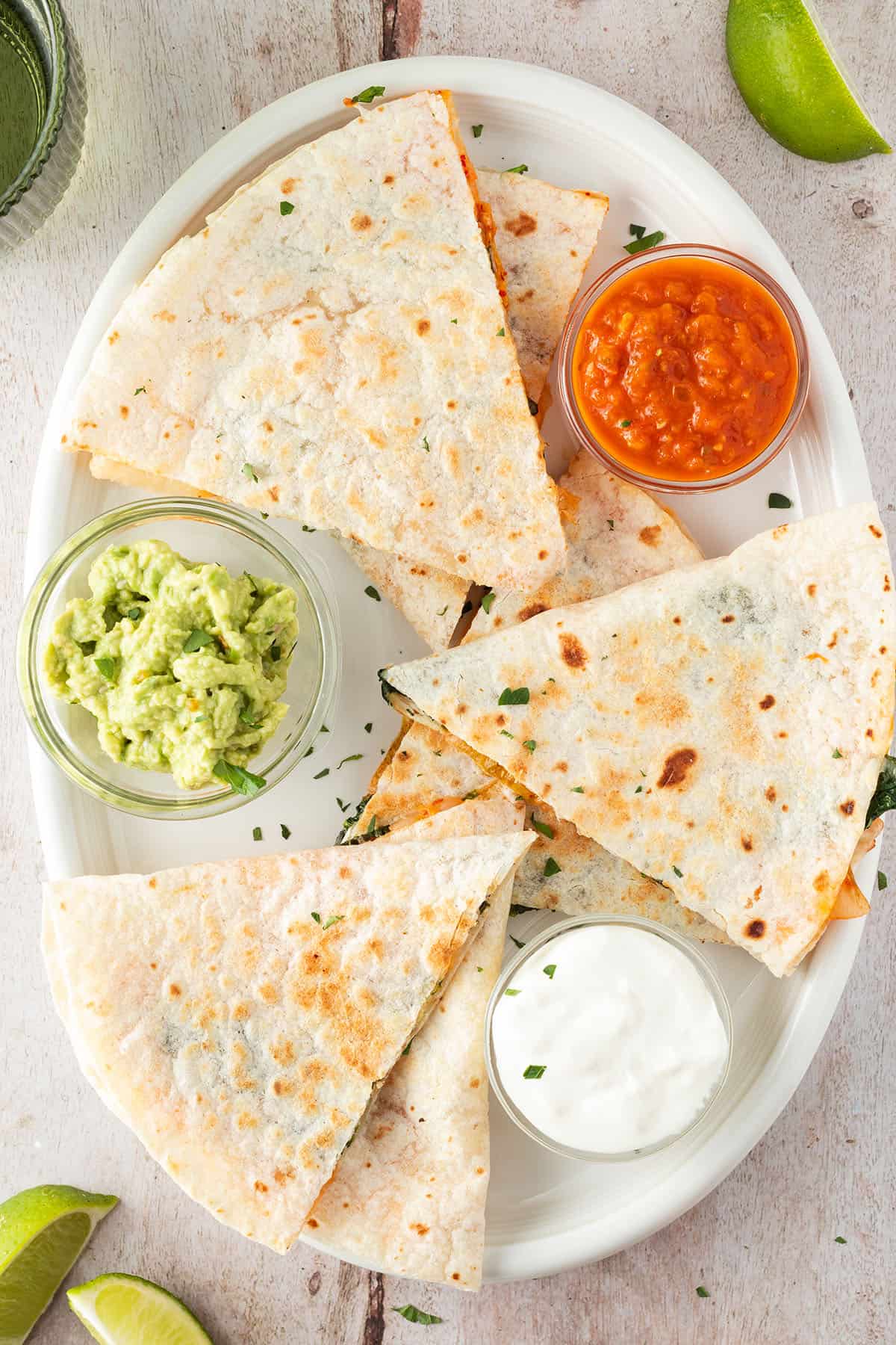 Kimchi Quesadilla auf einem Teller mit drei Dips, Deko im Bildrand.