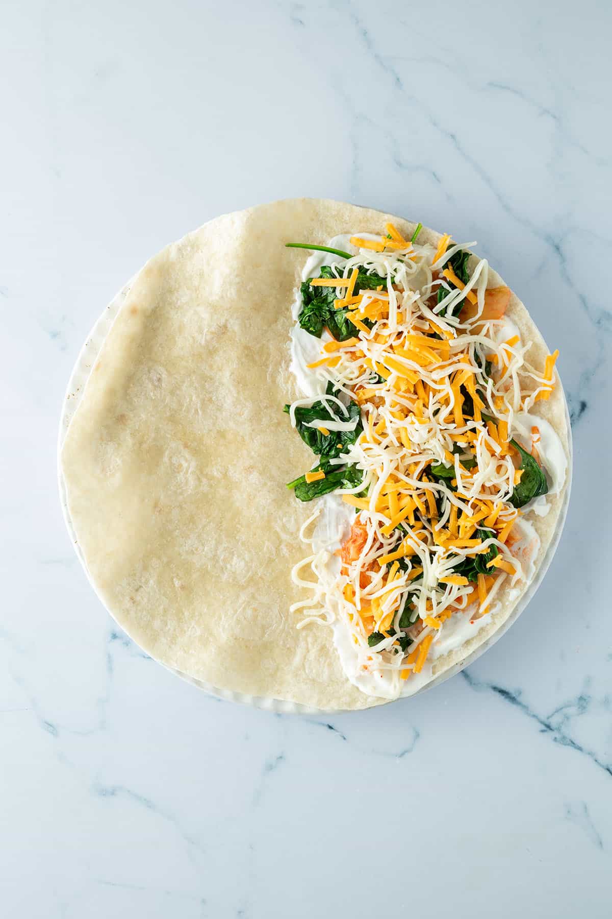 Eine H&auml;lfte des Tortillas wurde mit Schmand, Spinat, Kimchi und K&auml;se belegt.
