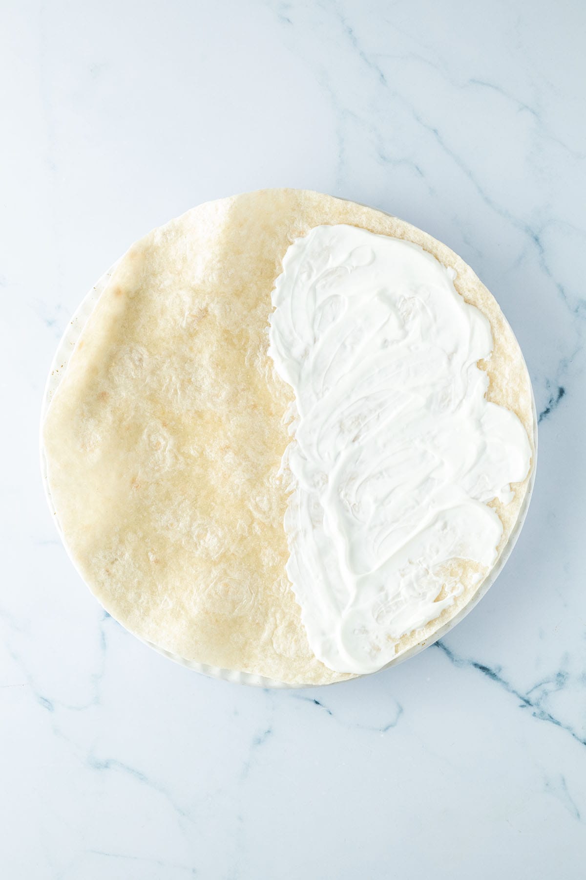 Eine H&auml;lfte des Tortillas wurde mit Schmand bestrichen.