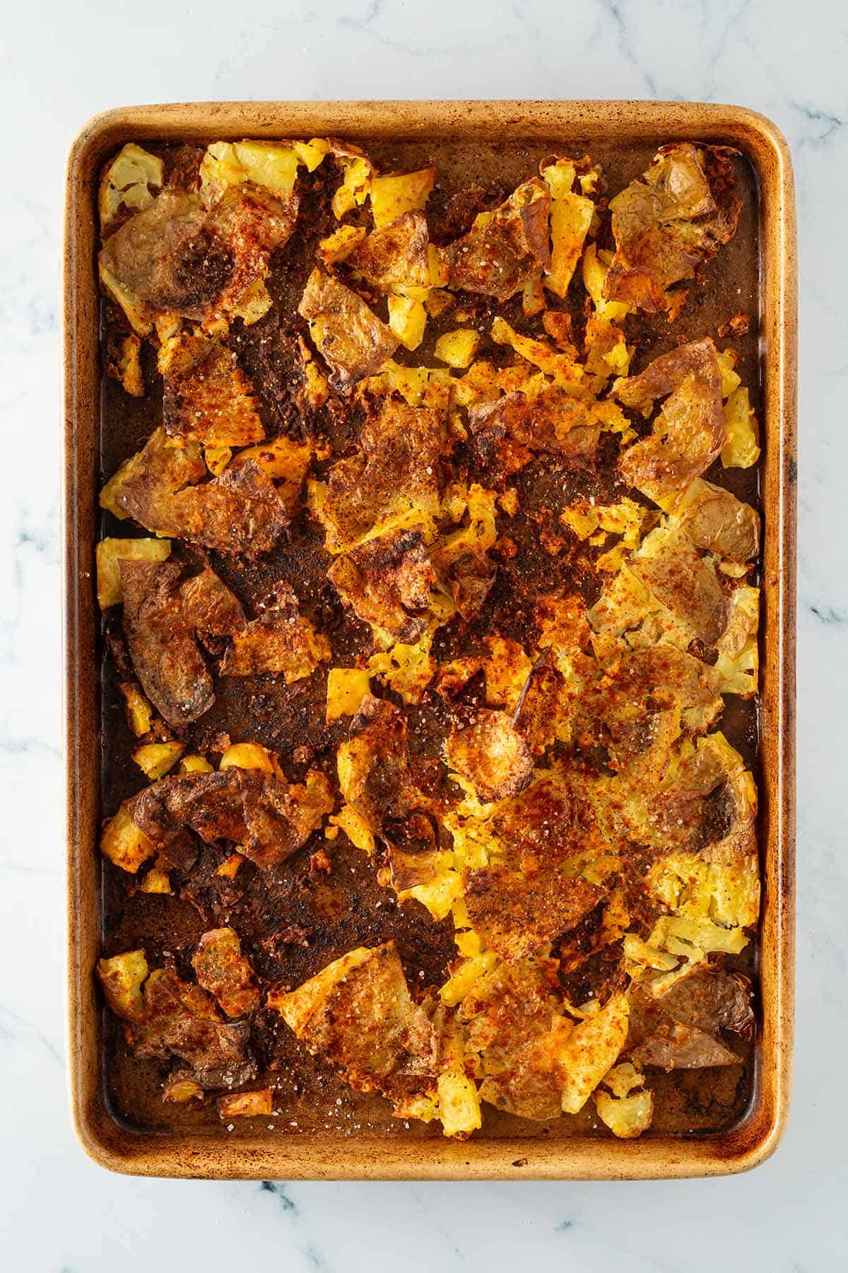 Knusprig ger&ouml;stete Quetschkartoffeln auf einem Blech.
