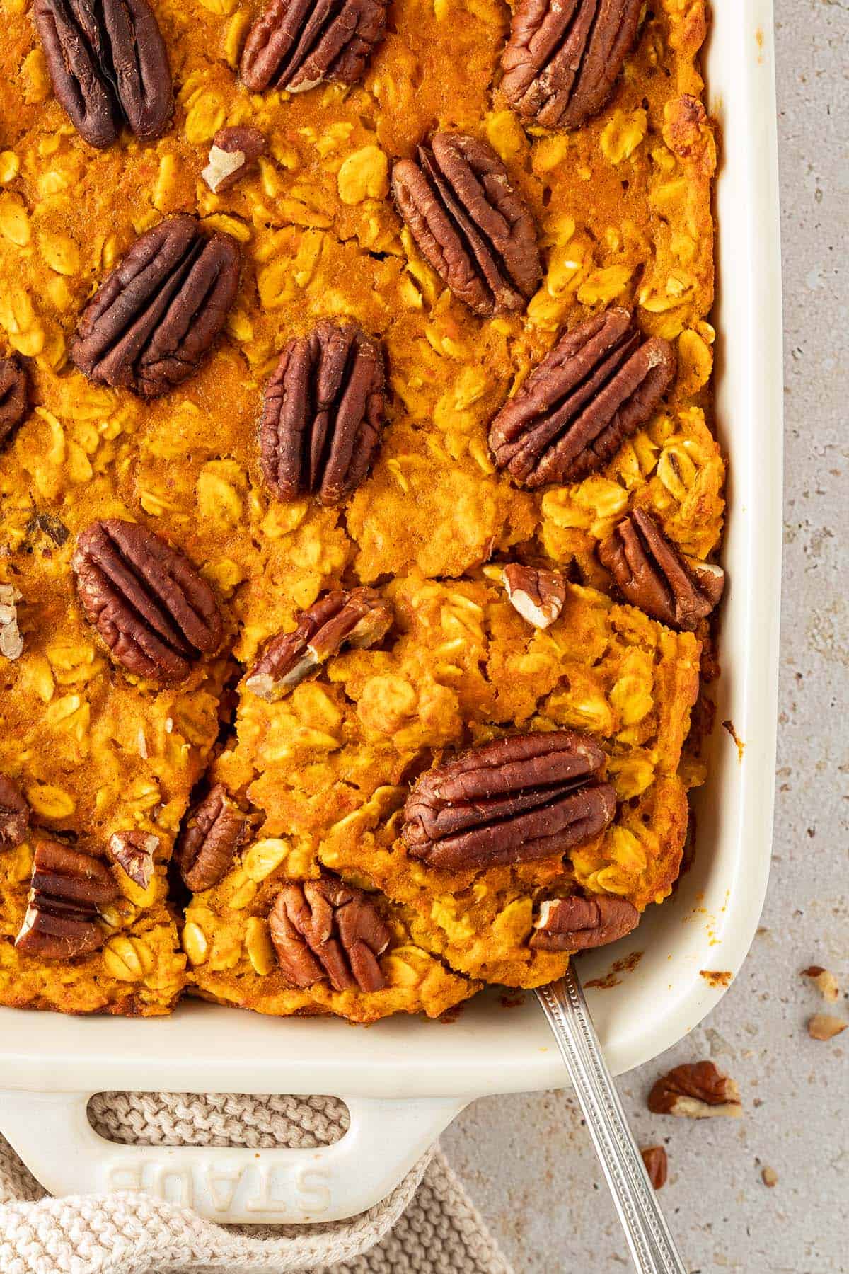 Eine Portion Baked Oats wird mit einem L&ouml;ffel aus der Auflaufform herausgenommen.