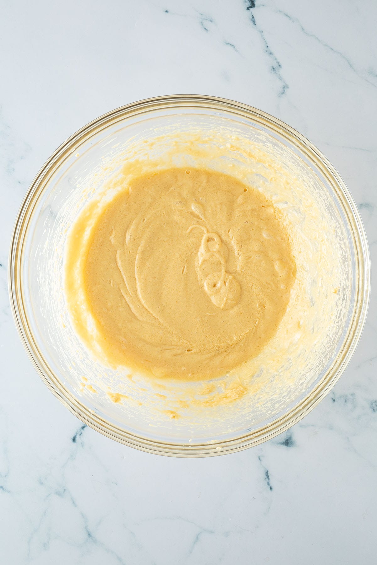 Butter, Zucker und Eier zu einer s&auml;migen Masse verr&uuml;hrt in einer R&uuml;hrsch&uuml;ssel.