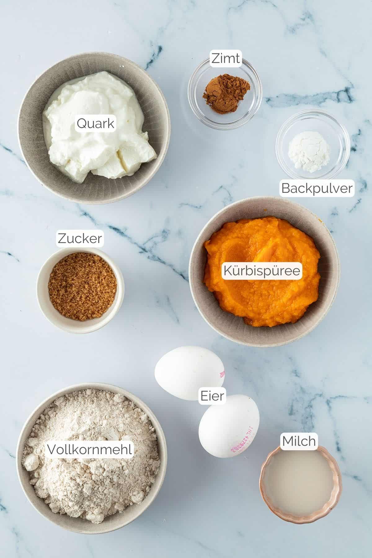 Alle Zutaten mit jeweiligen Textbeschriftungen, die f&uuml;r den K&uuml;rbis Kaiserschmarrn ben&ouml;tigt werden.