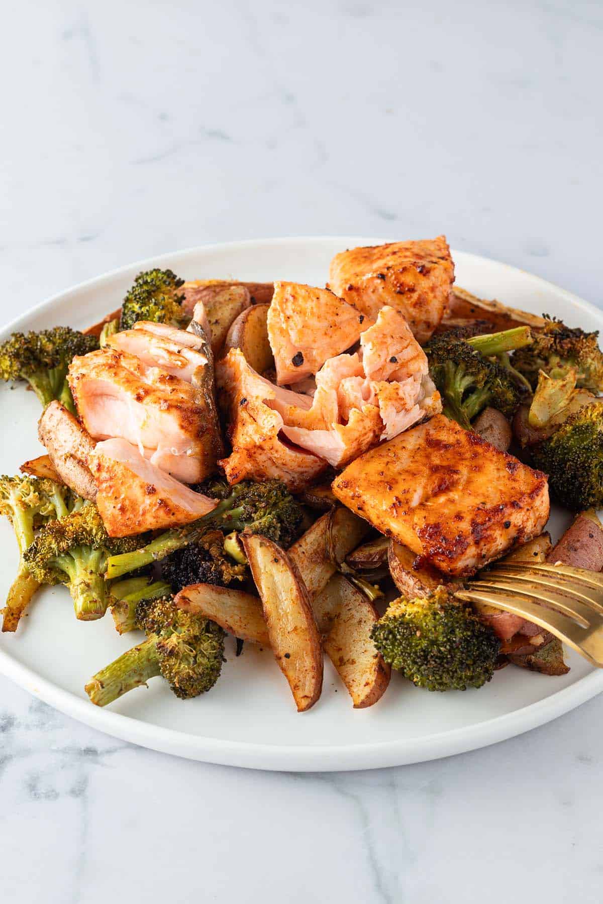 Teller mit Lachs, Kartoffeln und Brokkoli aus dem Ofen.