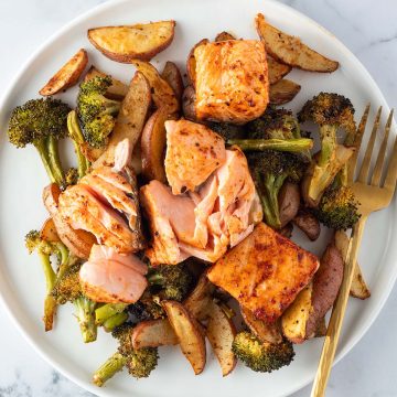 Teller mit Lachs, Kartoffeln und Brokkoli aus dem Ofen.
