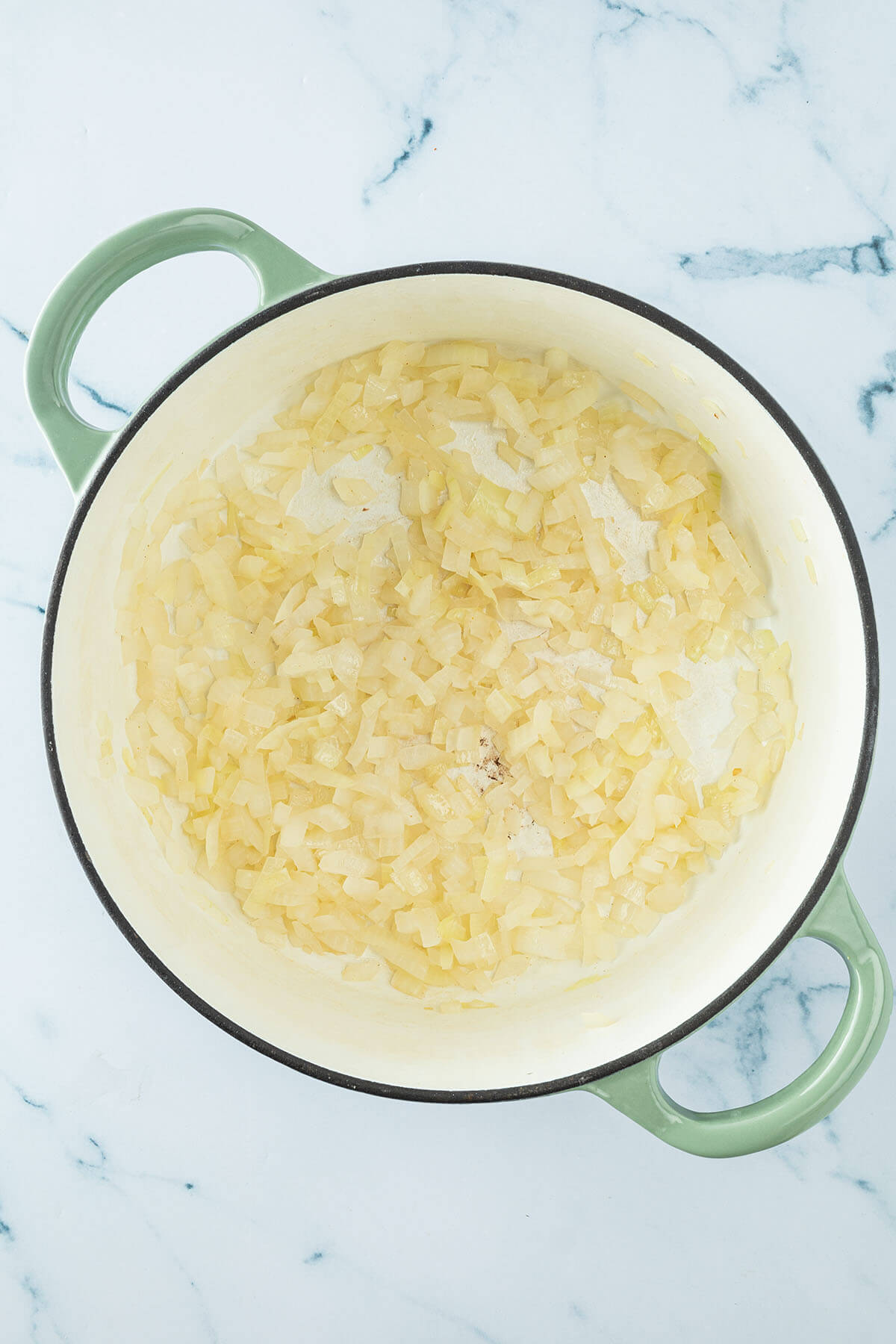 Weich ged&uuml;nstete Zwiebelw&uuml;rfel in einem Topf.