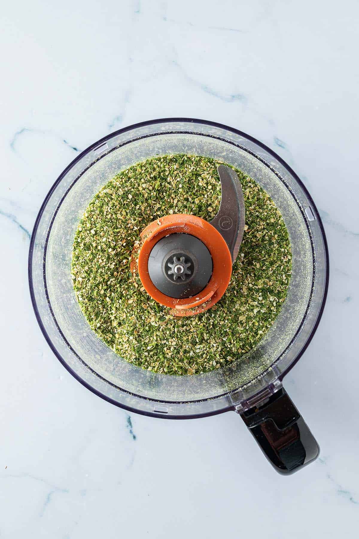 Fein zerkleinere Haferflocken und Petersilie in einem Food Processor.
